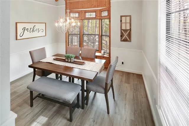 a view of a dining room with furniture a chandelier and wooden floor