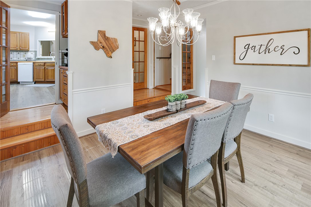 8010 Perry Lane College Station, TX 77845 - Photo 22 of 47 a view of a dining room with furniture a chandelier and wooden floor