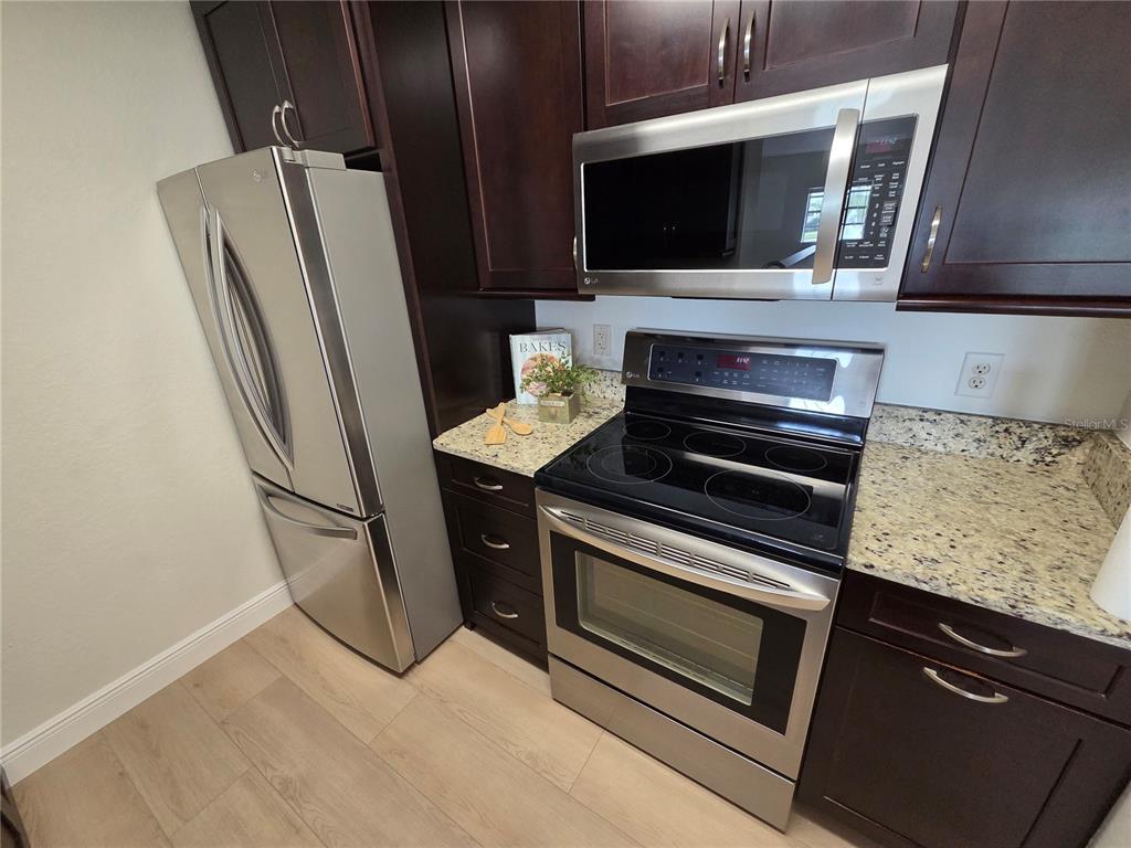 8905 Manor Loop, Unit 205 Lakewood Ranch, FL 34202 - Photo 14 of 30 a kitchen with stainless steel appliances a refrigerator stove and microwave