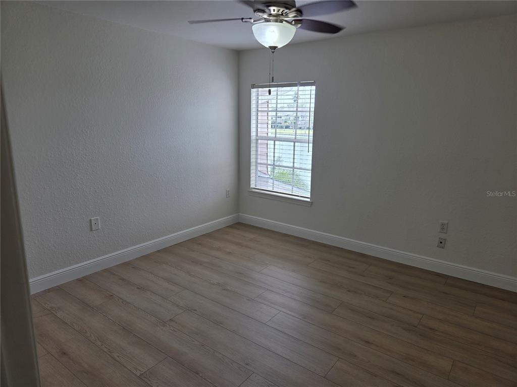 8905 Manor Loop, Unit 205 Lakewood Ranch, FL 34202 - Photo 16 of 30 an empty room with wooden floor and windows