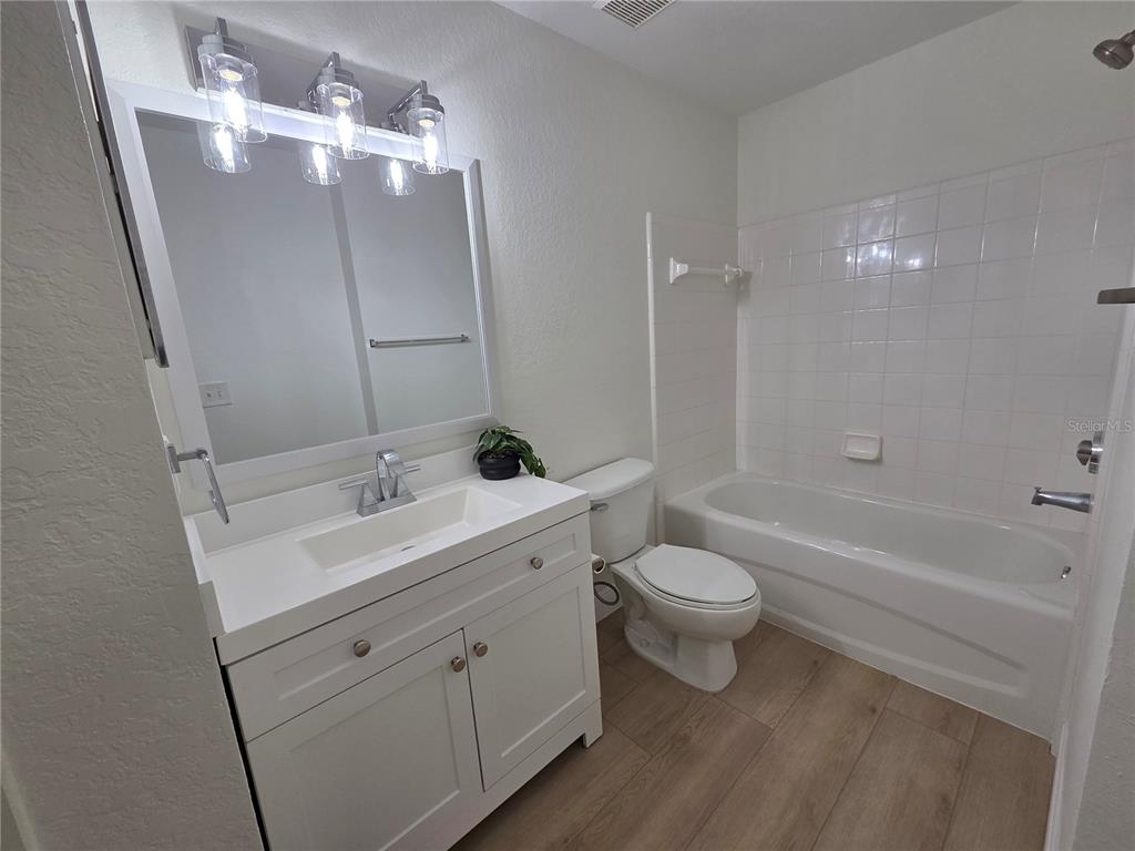 8905 Manor Loop, Unit 205 Lakewood Ranch, FL 34202 - Photo 19 of 30 a bathroom with a toilet a sink a tub and mirror