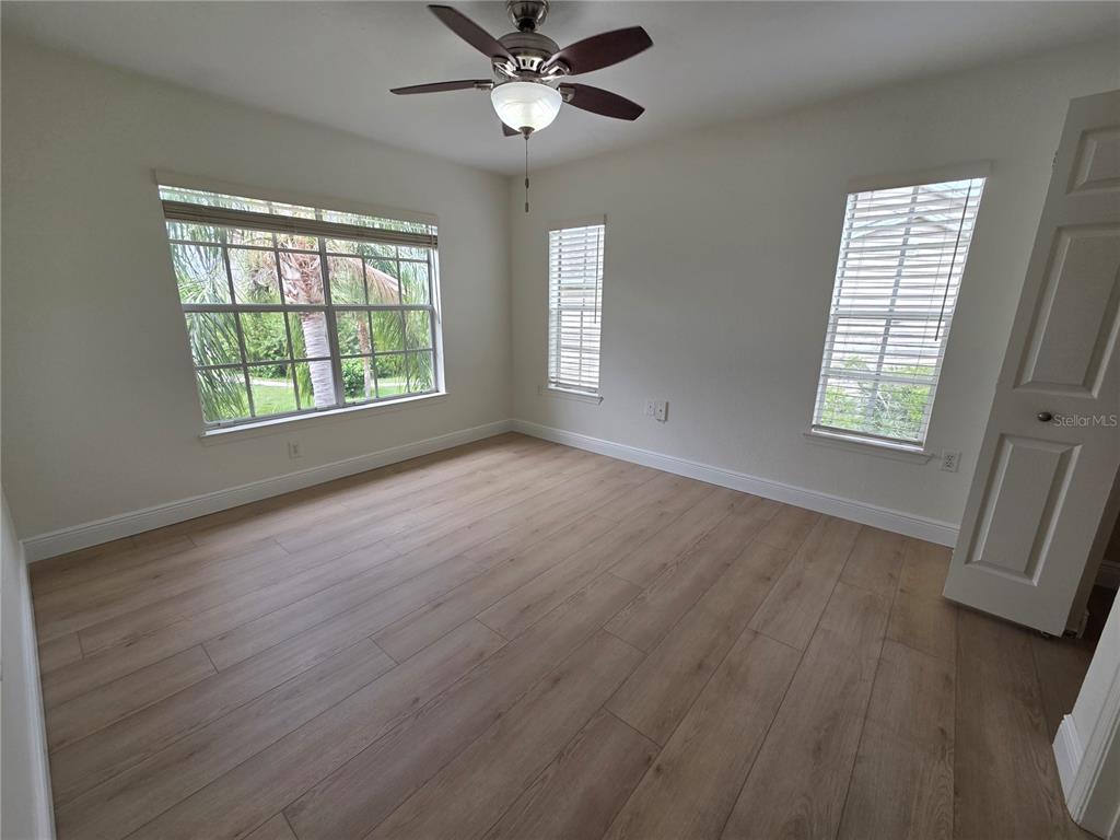 8905 Manor Loop, Unit 205 Lakewood Ranch, FL 34202 - Photo 21 of 30 a view of an empty room with wooden floor and a window