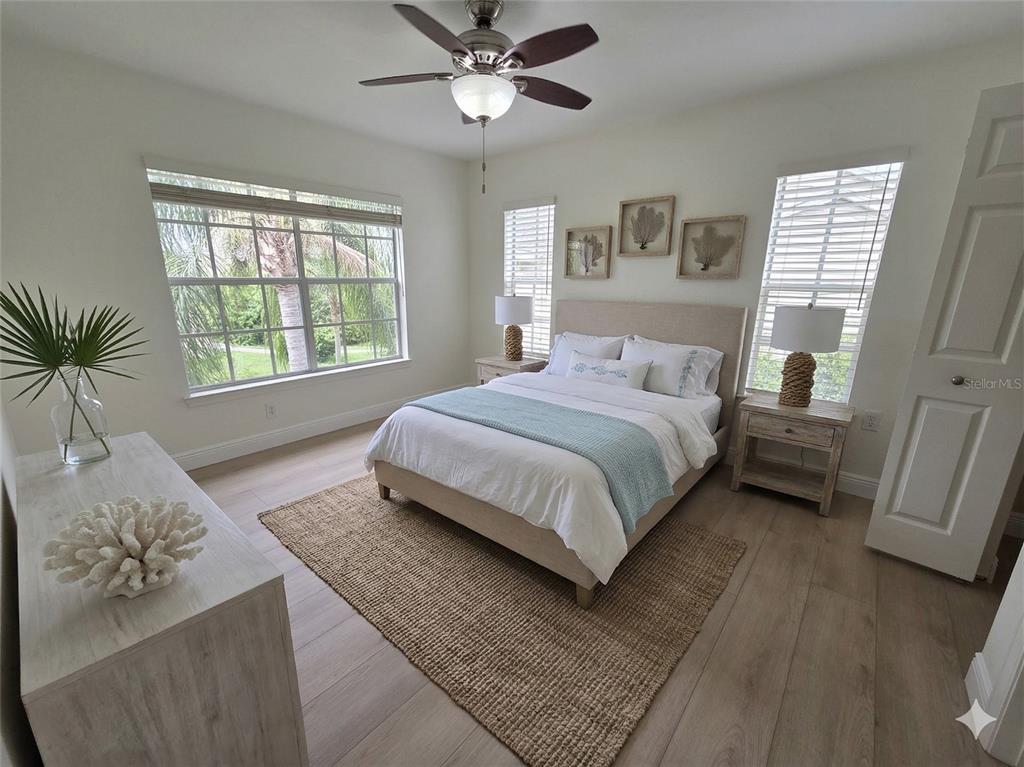 8905 Manor Loop, Unit 205 Lakewood Ranch, FL 34202 - Photo 22 of 30 a bedroom with a large bed and a couch