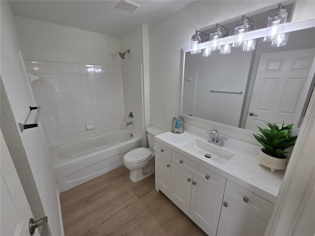 8905 Manor Loop, Unit 205 Lakewood Ranch, FL 34202 - Photo 25 of 30 a bathroom with a double vanity sink toilet and shower