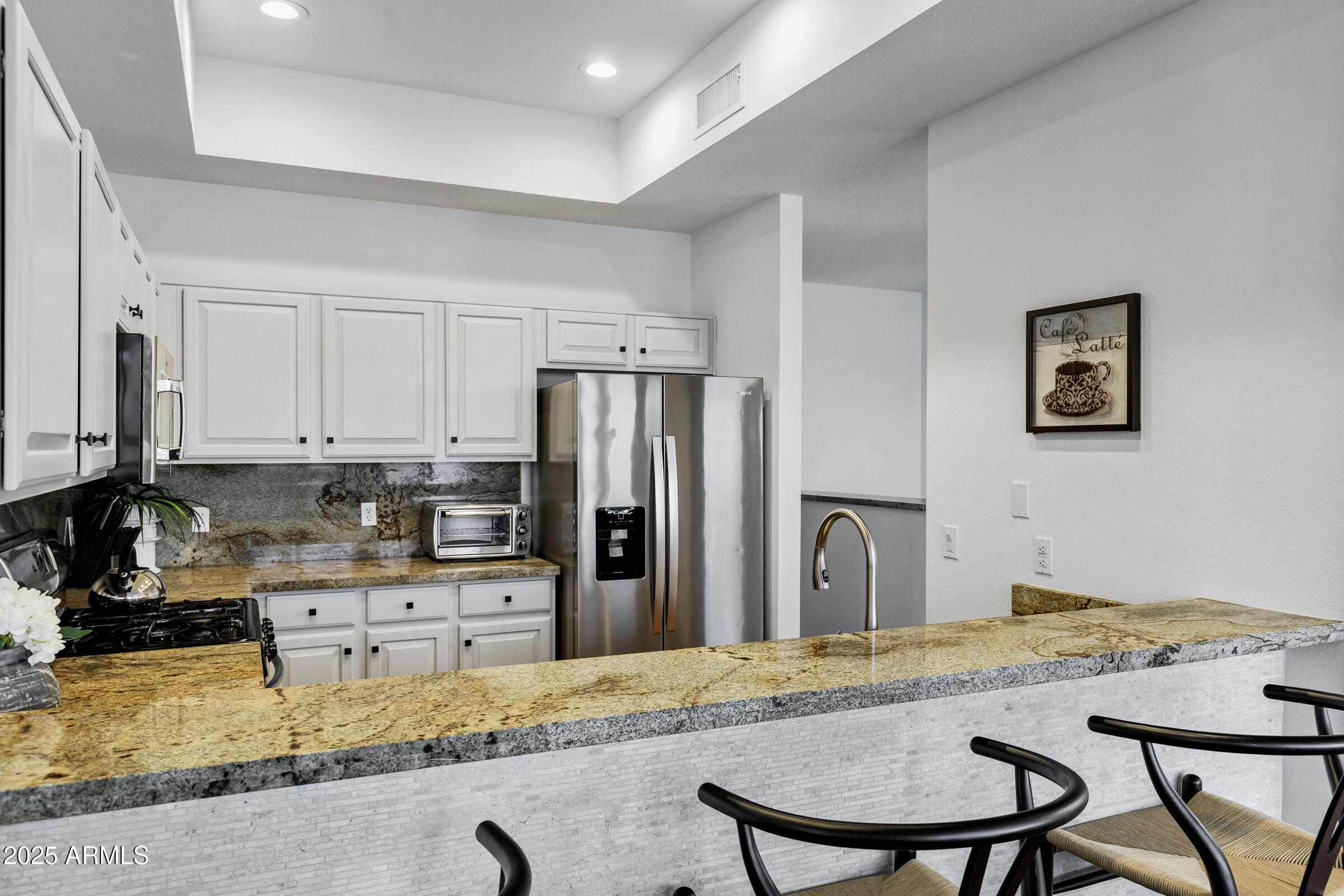 8270 North Hayden Road, Unit 2010 Scottsdale, AZ 85258 - Photo 15 of 54 a kitchen with granite countertop a refrigerator and a stove top oven