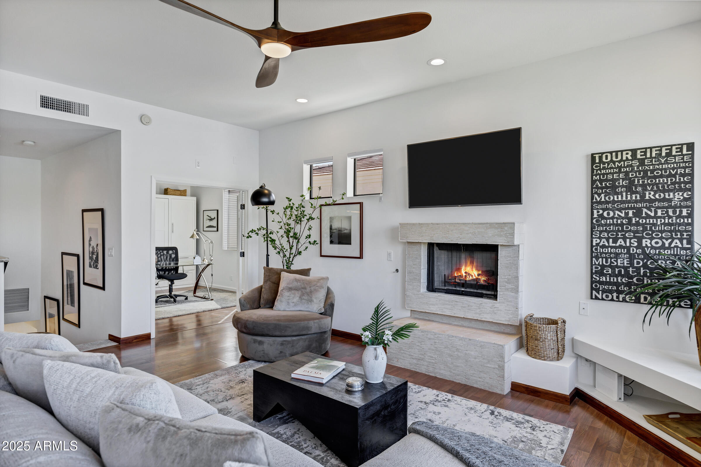 8270 North Hayden Road, Unit 2010 Scottsdale, AZ 85258 - Photo 6 of 54 a living room with furniture a flat screen tv and a fireplace