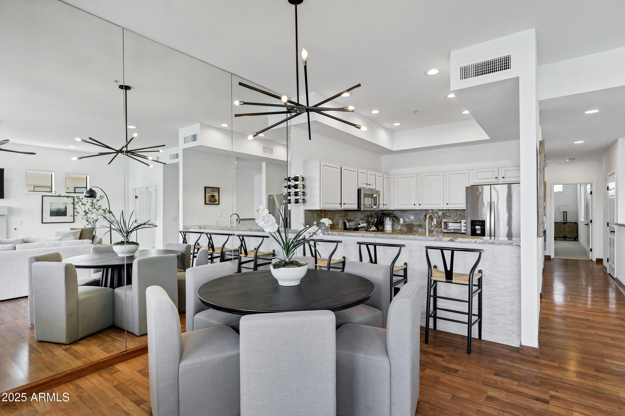 8270 North Hayden Road, Unit 2010 Scottsdale, AZ 85258 - Photo 8 of 54 a kitchen with stainless steel appliances kitchen island granite countertop a dining table chairs and white cabinets