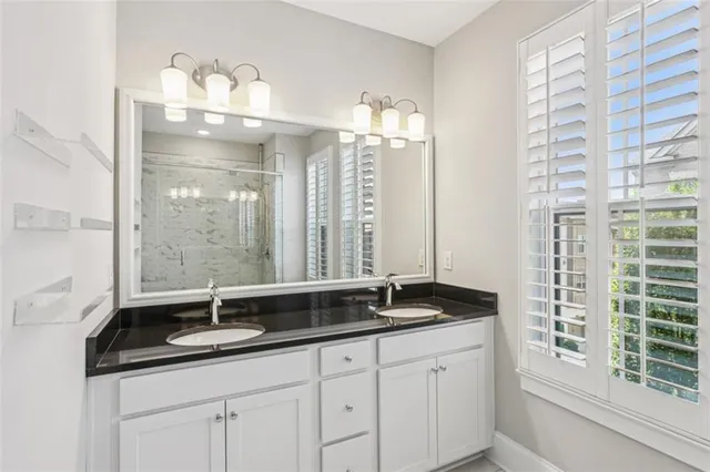 a bathroom with double vanity and a mirror