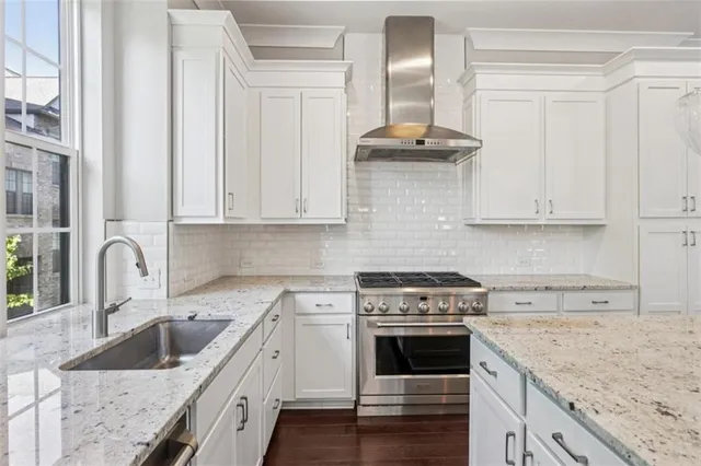 a kitchen with granite countertop a stove sink and cabinets