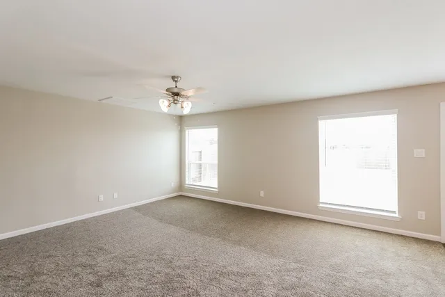 an empty room with a windows and chandelier