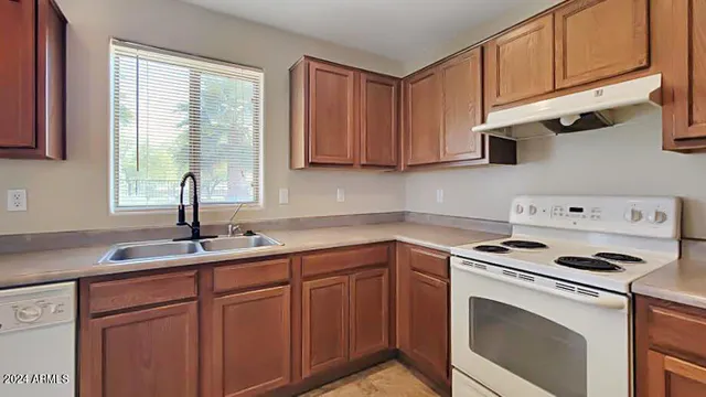 a kitchen with cabinets appliances a sink and a window