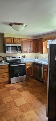 a kitchen with stainless steel appliances granite countertop a stove a sink and a refrigerator