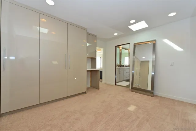 an empty room with a bathroom and a mirror