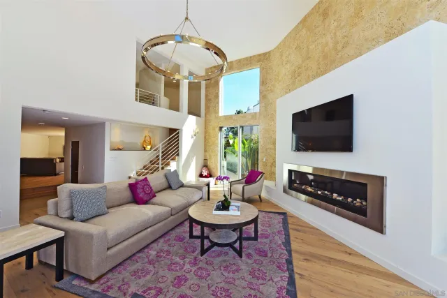 a living room with furniture a flat screen tv and a chandelier