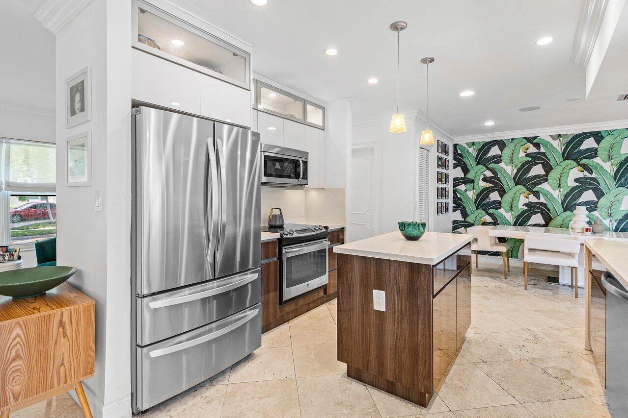 1181 Walnut Terrace Boca Raton, FL 33486 - Photo 11 of 26 a kitchen with kitchen island a counter top space a sink stainless steel appliances and cabinets