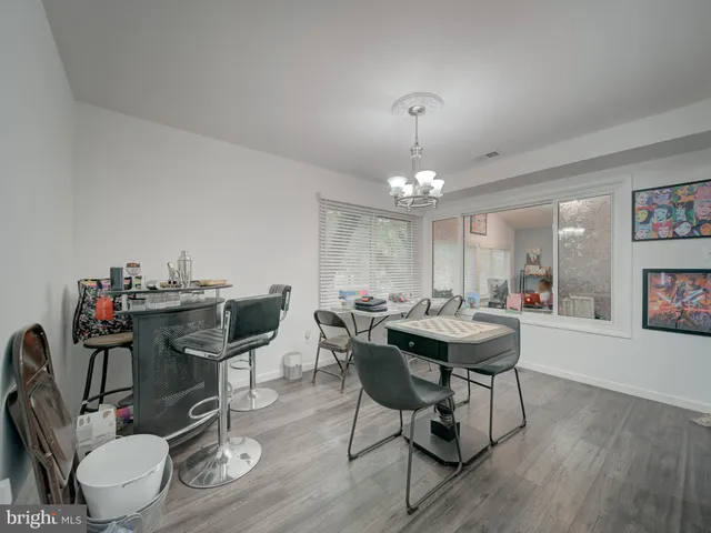 a view of a dining room with furniture a chandelier and wooden floor