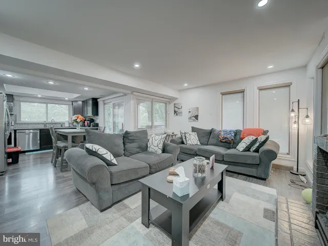 a living room with furniture and view of kitchen