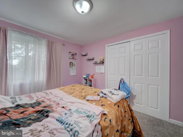 a spacious bedroom with a bed and a dresser