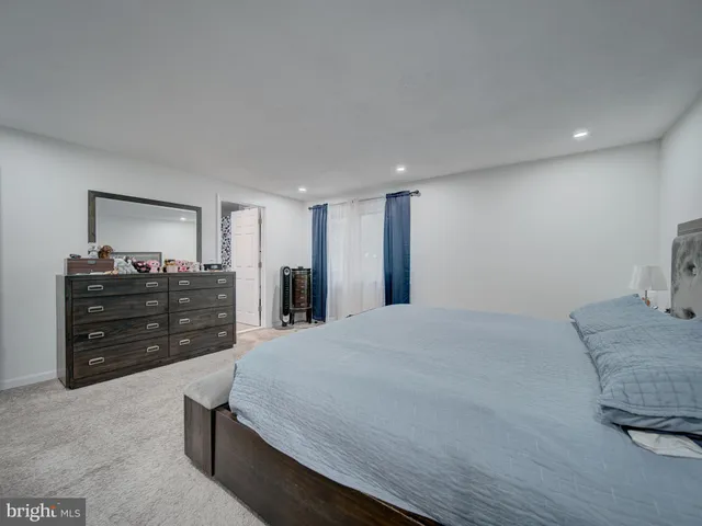 a large bedroom with a bed and a flat screen television