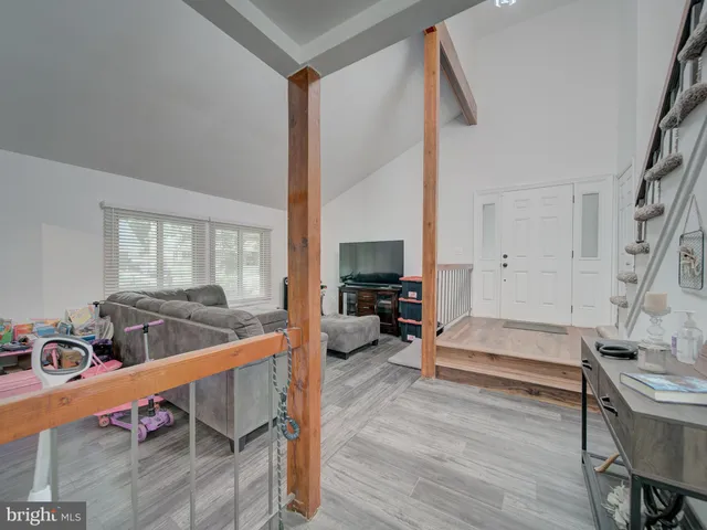 a living room with furniture a flat screen tv and a large window