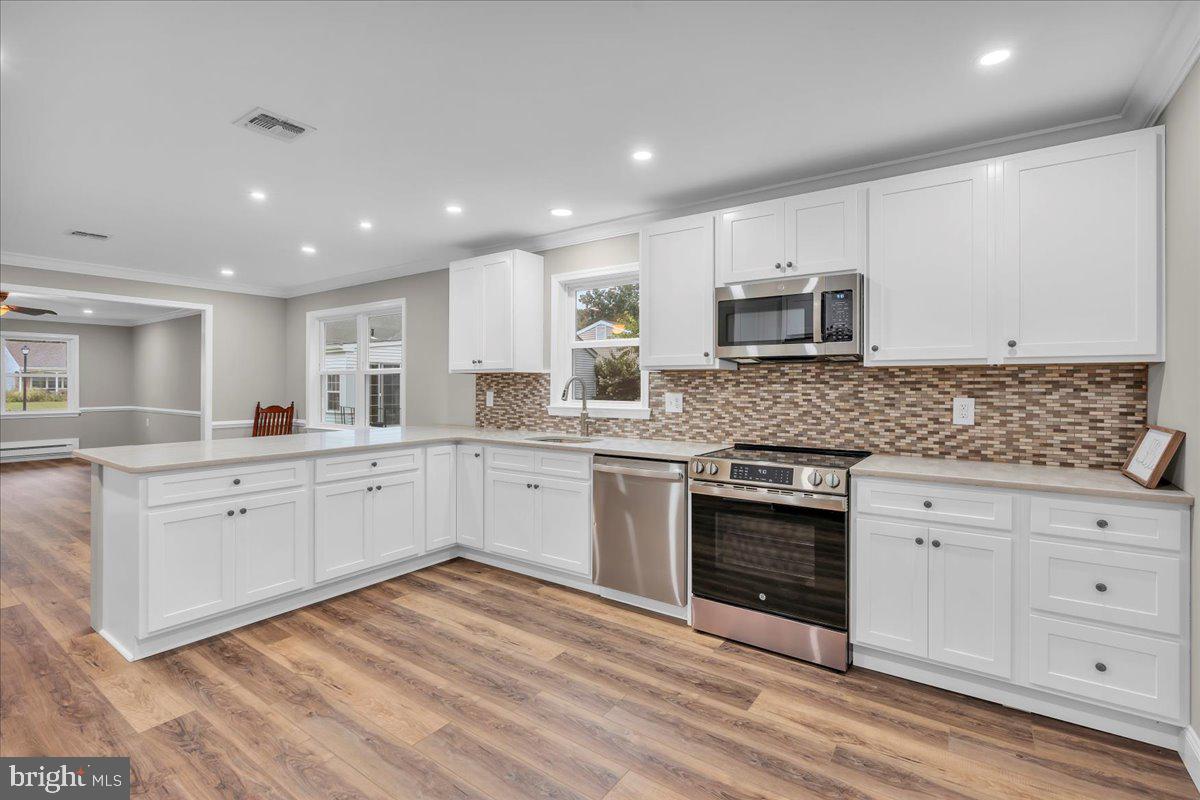 39 Chelsea Place Southampton, NJ 08088 - Photo 4 of 23 a kitchen with stainless steel appliances granite countertop a stove top oven a sink and white cabinets