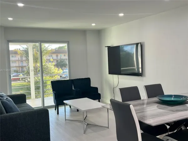 a living room with furniture and a floor to ceiling window
