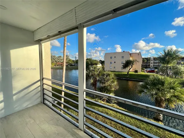 a view of a balcony with floor to ceiling windows with wooden floor