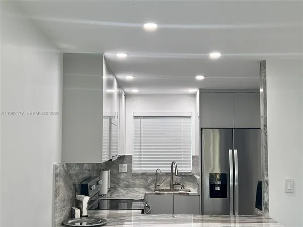 a kitchen with stainless steel appliances granite countertop a refrigerator and a sink