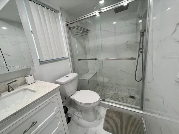 a bathroom with a sink toilet and shower