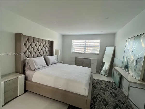 a bedroom with a bed a couch and dresser