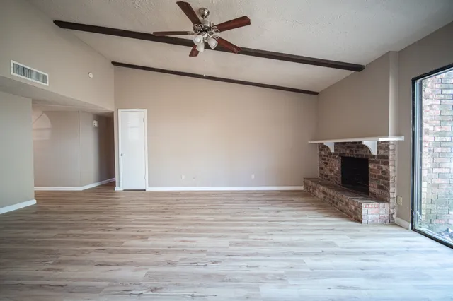 a view of empty room with wooden floor and fireplace