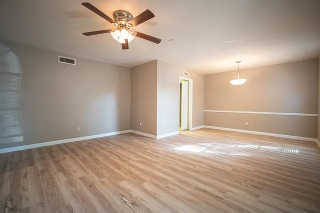 a view of an empty room with window and a ceiling fan