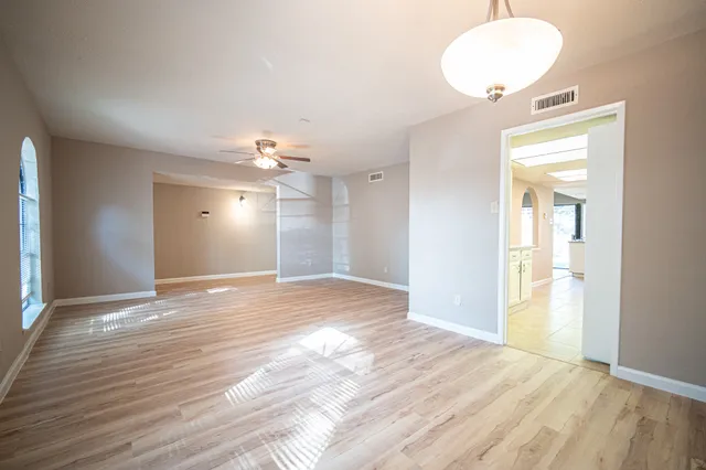 a view of an empty room and window and wooden floor