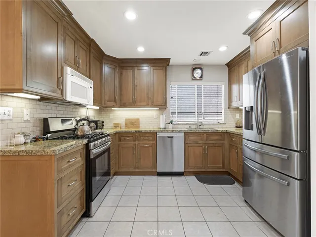 a kitchen with a sink a refrigerator and cabinets