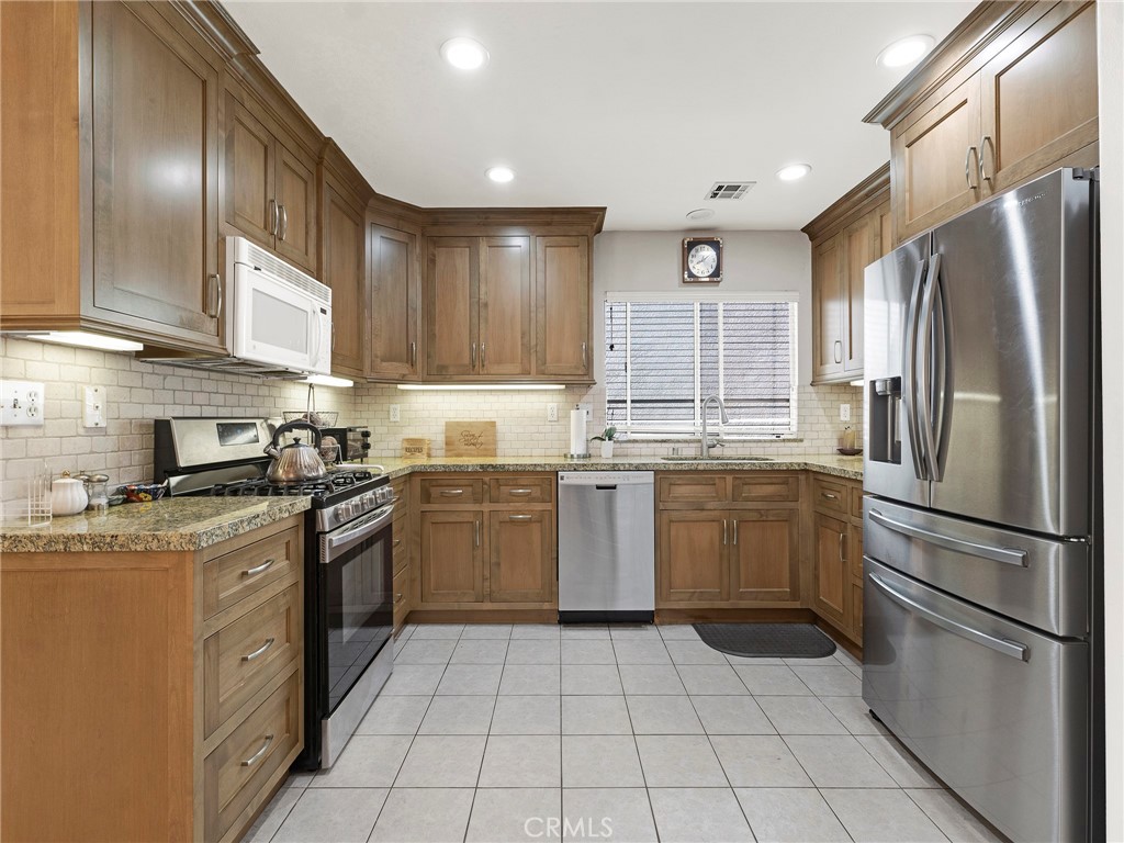 5621 Daisy Street Simi Valley, CA 93063 - Photo 15 of 31 a kitchen with a sink a refrigerator and cabinets