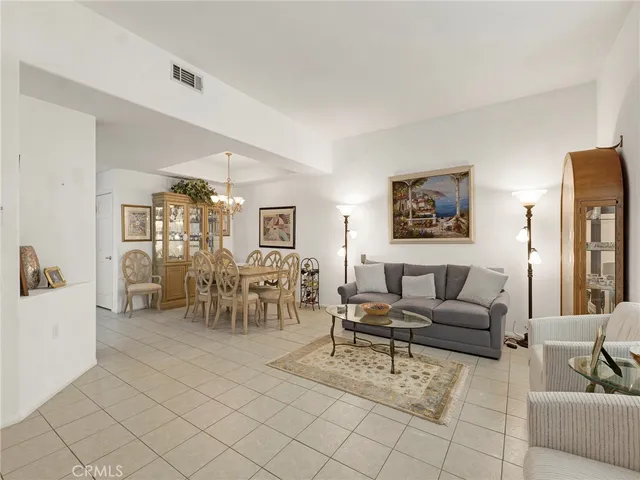 a living room with furniture and a dining table with chairs
