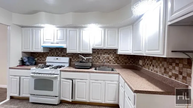 a kitchen with white cabinets and white appliances