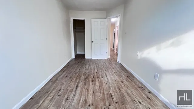 a view of a room with wooden floor and a ceiling fan
