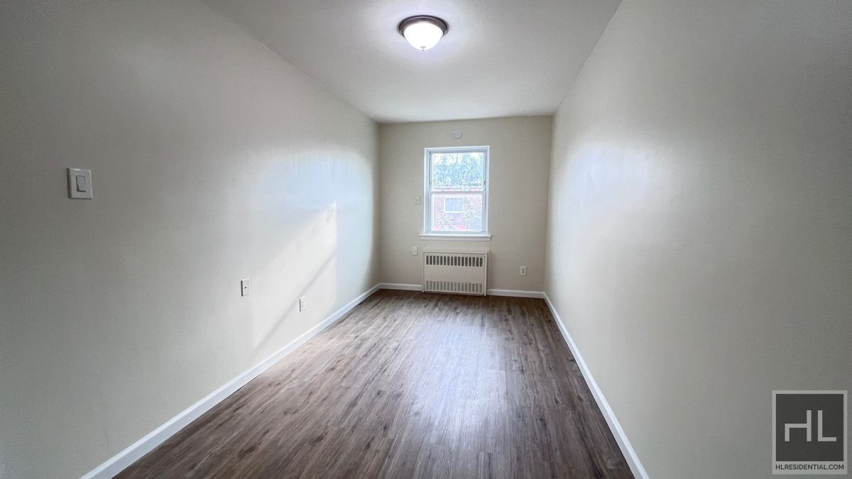 2070 East 55th Street, Unit 2 Brooklyn, NY 11234 - Photo 9 of 23 a view of an empty room with wooden floor and a window