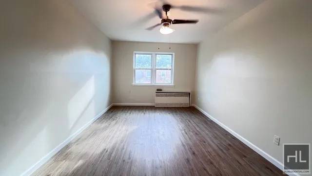 a view of room with window ceiling fan and hardwood floor