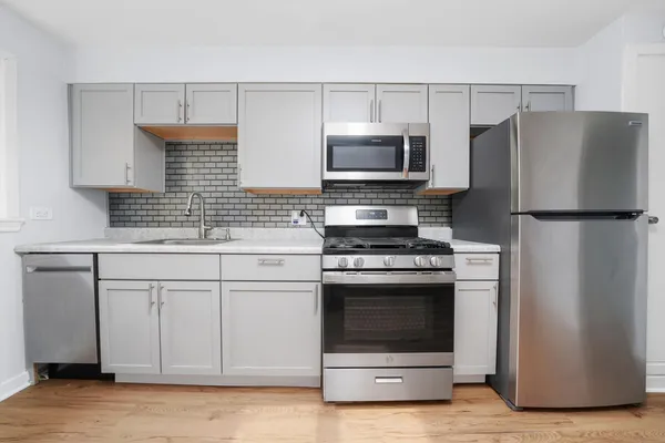a kitchen with white cabinets and stainless steel appliances