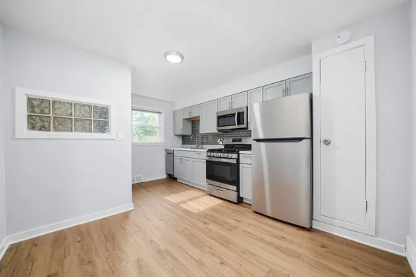a kitchen with wooden floors and white appliances