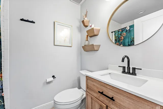 a bathroom with a toilet a sink and mirror