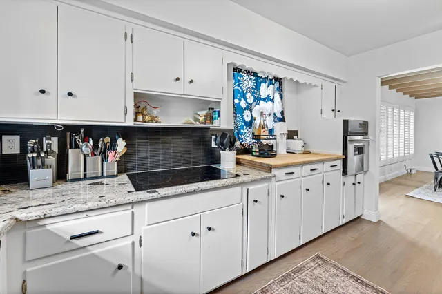 a kitchen with granite countertop white cabinets and white appliances