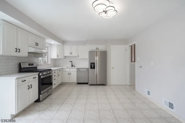 a large kitchen with cabinets and stainless steel appliances