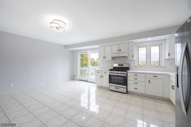 a kitchen with granite countertop a stove a sink and a refrigerator