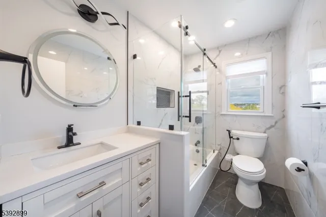a bathroom with a toilet a sink a mirror and a bathtub