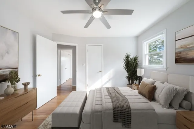 a bedroom with a large bed and a chandelier fan