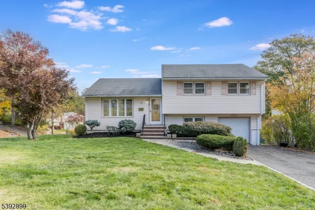 a front view of a house with a garden and trees