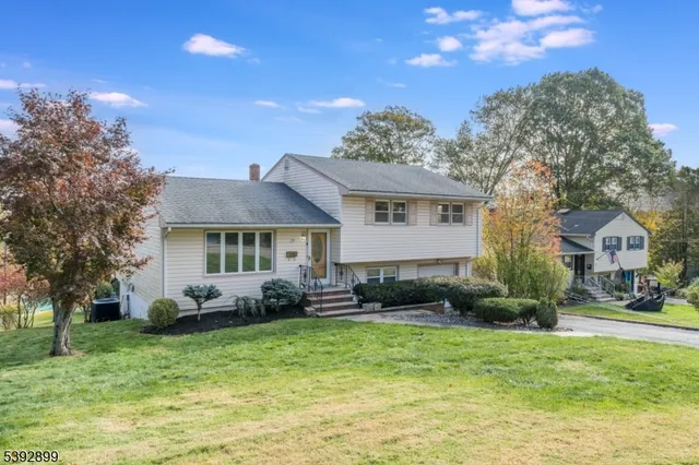 a front view of a house with a yard and trees